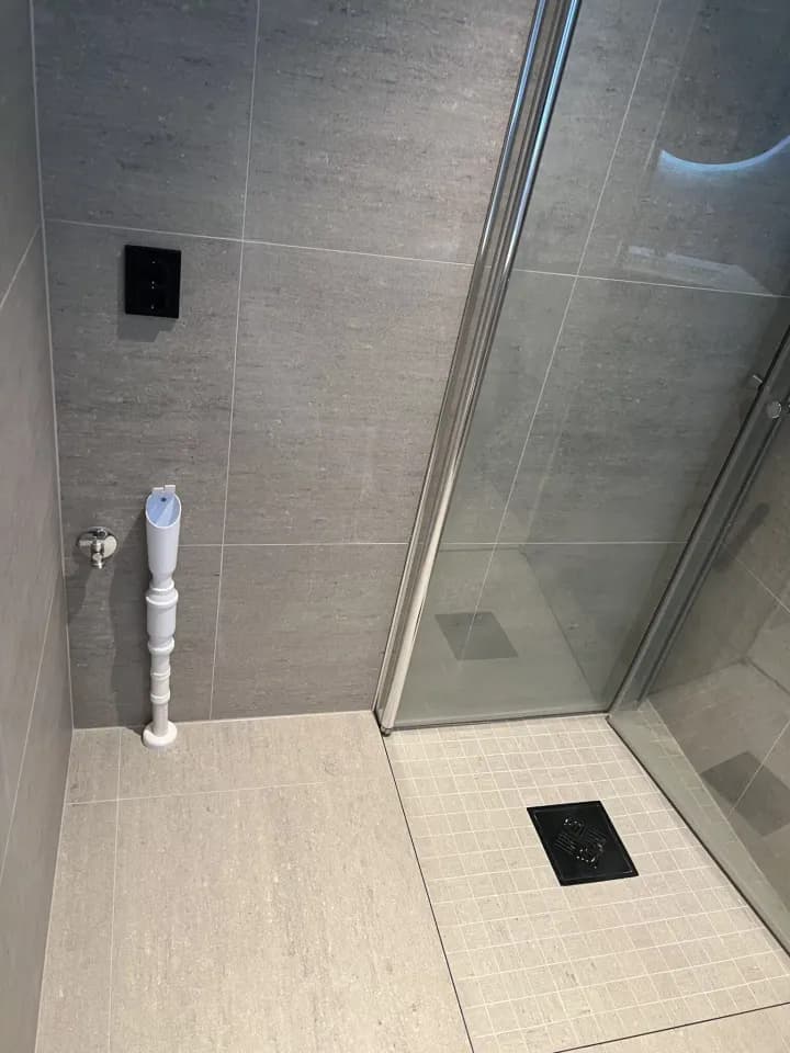 Grå flislagt dusjnisje med glassvegg i lite baderom, Eftasåsen 9, Oslo